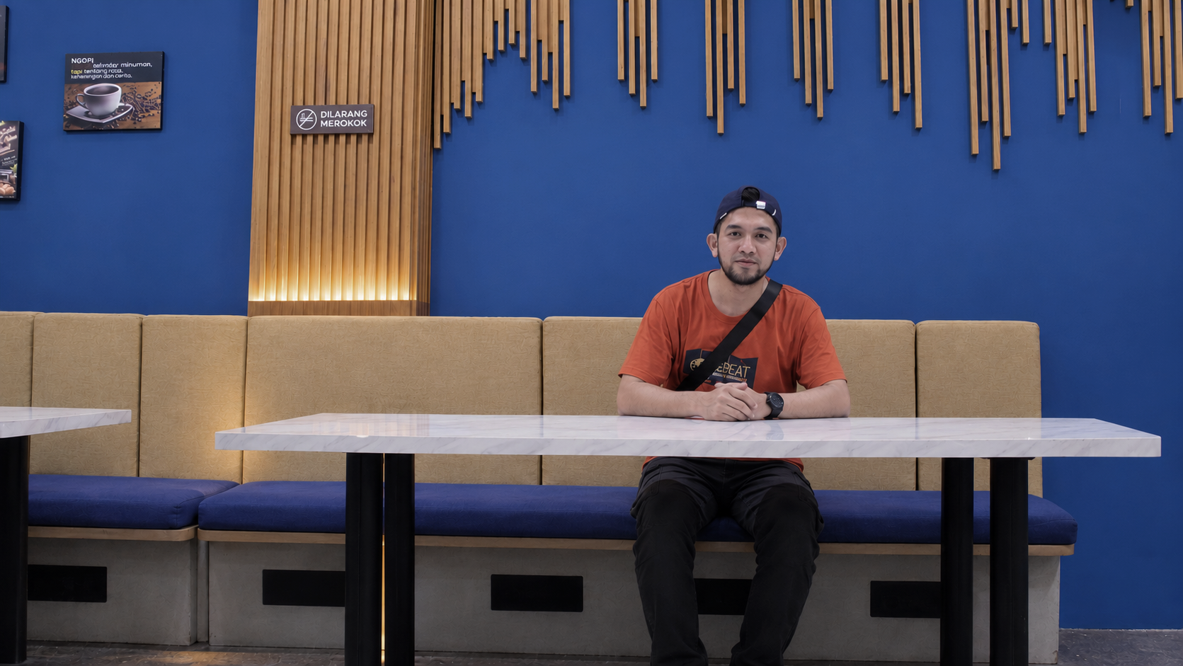 Forward-Facing Man in Modern Blue Cafe (1)